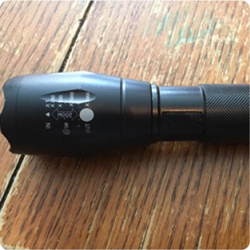VitalTac Flashlight on a wood surface